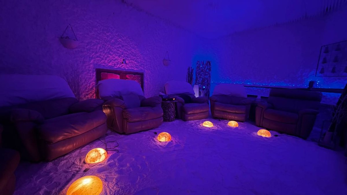 The salt cave at Salinair Salt Room Spa set with recliner seating and glowing Himalayan salt lamps